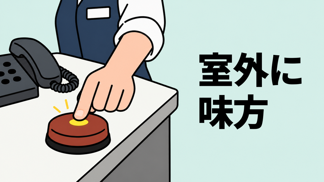 相談室の机で、窓口職員の手が丸いヘルプボタンを押すイラスト。左奥には固定電話が置かれている。