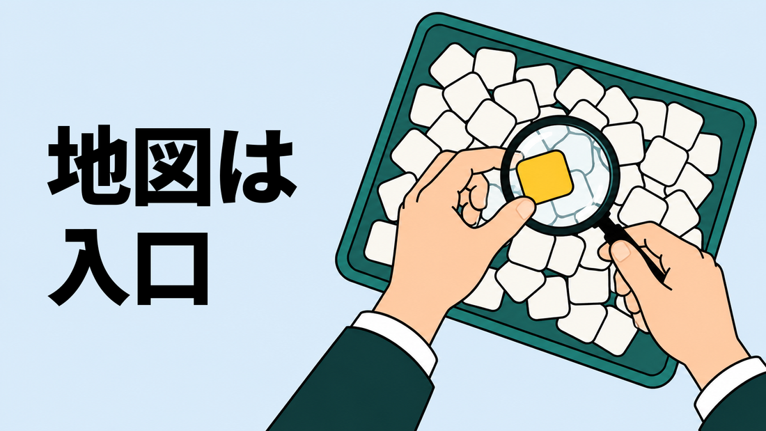 真上から見た作業台で、片手が無地のタイルの集まりから黄色い1枚をつまみ、もう片方の手が虫眼鏡をかざしている。
